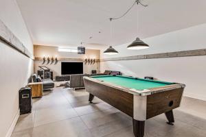 a living room with a pool table in the middle at Landgoed Hermitage - Villa Minerva - XXL Zwemspa - max 16 personen in Ouddorp