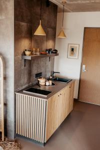 a kitchen with a stove, sink, and cabinets at Strandhotel Zoomers in Castricum