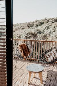 a balcony with two chairs and a table on a deck at Strandhotel Zoomers in Castricum