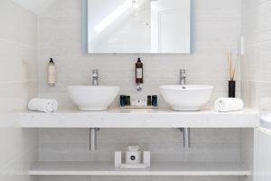 a white bathroom with two sinks and a mirror at Ballyliffin TownHouse Boutique Hotel in Ballyliffin
