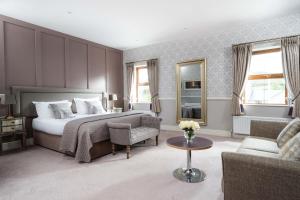 a bedroom with a bed and a couch and a table at Ballyliffin TownHouse Boutique Hotel in Ballyliffin
