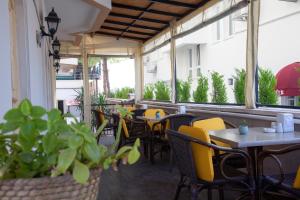 an empty restaurant with tables and yellow chairs at Nasa Flora Hotel in Antalya