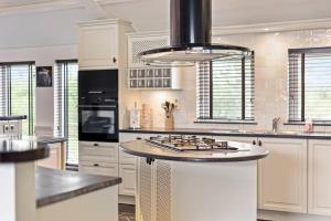 a large kitchen with a island in the middle at Landgoed Hermitage - Villa Euphoria - XXL Zwemspa - Max 10 personen in Ouddorp