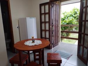 a kitchen with a wooden table and a refrigerator at Residencial Lumar in Itapoa