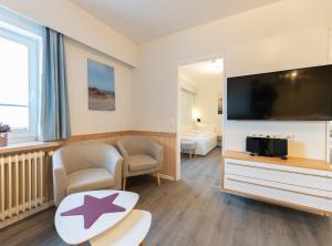 een woonkamer met een grote flatscreen-tv bij Appartement Beka 15 in Westerland