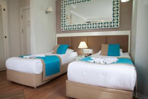 two beds in a hotel room with a mirror at Nasa Flora Hotel in Antalya +52 photos