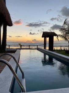 a swimming pool with a view of the ocean at Club Manguaba Beira Mar in Japaratinga