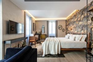ein Hotelzimmer mit einem Bett und einem Sofa in der Unterkunft Le Dortoir Boutique Suites in Nizza