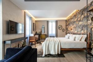 ニースにあるLe Dortoir Boutique Suitesのベッドとソファのあるホテルの部屋