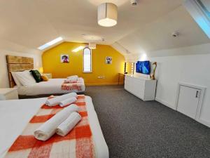 a large room with two beds and a television at The Nook - TV in Every Bedroom! in Swansea
