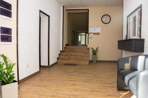 un couloir de bureau avec des escaliers et une horloge sur le mur dans l'établissement Monada Hotel & Hostel, à Oujhorod
