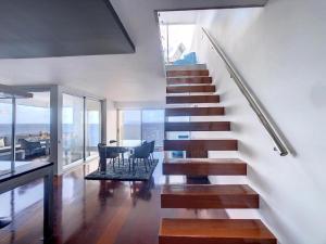 eine Treppe in einem Haus mit einem Wohnzimmer in der Unterkunft Luxurious Penthouse Suite direct at sea in Caniço