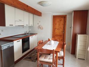 - une cuisine avec une table en bois, des chaises et un évier dans l'établissement Appartamento Vacanze La Maddalena, à La Maddalena