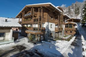 ein großes Holzhaus im Schnee in der Unterkunft Der Zirmhof in Saalbach in Saalbach-Hinterglemm