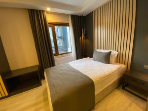 a small bedroom with a bed with a window at Antik Houses in Istanbul