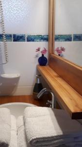 a bathroom with a bath tub and a sink and a tub at Arboleda Monoambiente in El Hoyo