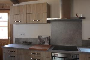 a kitchen with wooden cabinets and a stove top oven at Chalet Pomme de Pin in Tignes