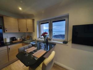 a kitchen with a table with chairs and a window at 22 Waters Edge Banff in Banff