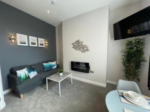 a living room with a couch and a tv at The Marlborough Sea View Holiday Apartments in Scarborough