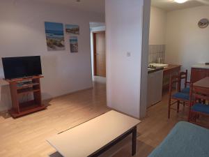 Televízia a/alebo spoločenská miestnosť v ubytovaní Apartments Kornati