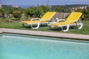 two lounge chairs sitting next to a swimming pool at Like-home-T2 house, pool, AC, garden in Ericeira