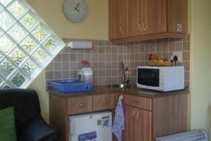 a kitchen with a microwave and a counter with a sink at Bienvenue Self Catering in Mossel Bay