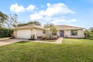 a house with a garage and a grass yard at Palm Frond Ranch in Naples