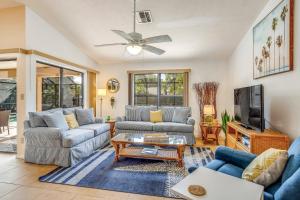 a living room with two couches and a tv at Palm Frond Ranch in Naples