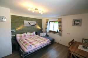 a bedroom with a bed and a table in it at Ferienwohnung Schildwolf in Fieberbrunn