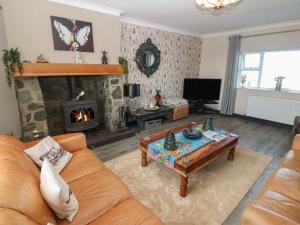 a living room with a couch and a fireplace at Trewan House in Holyhead