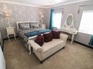 a bedroom with a bed and a couch and a mirror at Trewan House in Holyhead