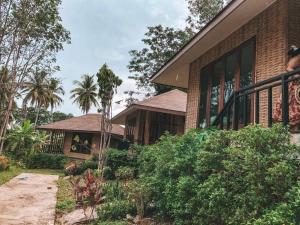 una casa in mattoni con portico e un edificio di The mantra resort a Ko Yao Yai
