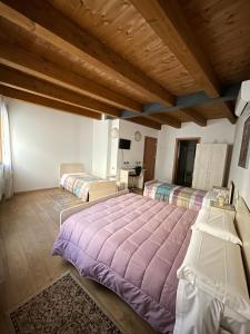 a bedroom with two beds and a wooden ceiling at La Casa del Sogno in Monteforte dʼAlpone