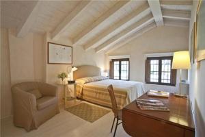 a bedroom with a bed and a desk and a chair at Resort Brandolini Rota in Cordignano