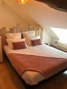 1 dormitorio con 1 cama grande con sábanas y almohadas blancas en Gite LA VUE LOIRE Appartement, en Saint-Denis-de lʼHôtel