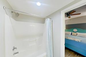 a bedroom with a blue bed and a ceiling fan at Shores of Panama III in Panama City Beach