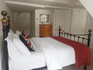 a bedroom with a bed with white sheets and a red blanket at Warwick Market Place Apartment in Warwick