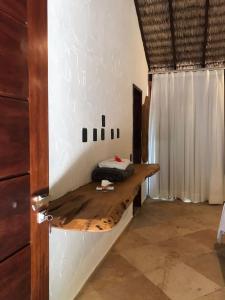 una habitación con un banco de madera en la pared en Pousada Rota dos Ventos en Barra Grande