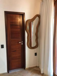 una puerta de madera con un espejo junto a una cortina en Pousada Rota dos Ventos en Barra Grande