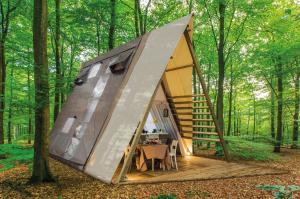 ein Zelt mit einem Tisch im Wald in der Unterkunft Casa Dei Prati Camping Village in Lacona