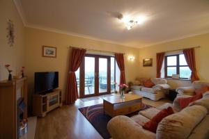 a living room with two couches and a tv at Blaengader Cottages - Enlli in Aberystwyth
