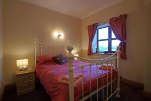 a bedroom with a bed and a window at Blaengader Cottages - Enlli in Aberystwyth