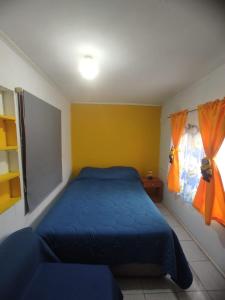 1 dormitorio con 1 cama azul y 2 ventanas en Descanso Tren del tata, en Quintero