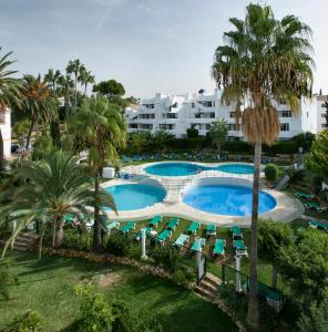 una vista aérea de una piscina del complejo con sillas y palmeras en Aparthotel Ona Campanario en La Cala de Mijas