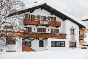 Un edificio cubierto de nieve con un balcón en la parte superior. en Hotel Kristall, en Lech am Arlberg