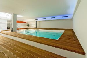 una gran piscina en una habitación con suelo de madera en HOTEL DÜNENLÄUFER Carolinensiel en Carolinensiel