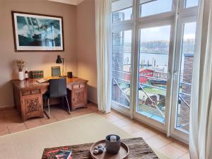 an office with a desk and a large window at Penthouse Hafenblick - private Sauna - Teil der HolidayEscapes Kollektion in Travemünde
