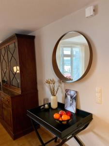 a table with a bowl of fruit and a mirror at Penthouse Hafenblick - private Sauna - Teil der HolidayEscapes Kollektion in Travemünde +11 photos