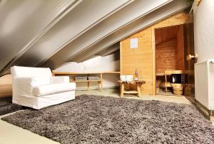 a living room with a white chair and a rug at Penthouse Hafenblick - private Sauna - Teil der HolidayEscapes Kollektion in Travemünde