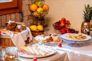 a table topped with plates of food and baskets of fruit at La Casa Gioconda in San Michele al Tagliamento